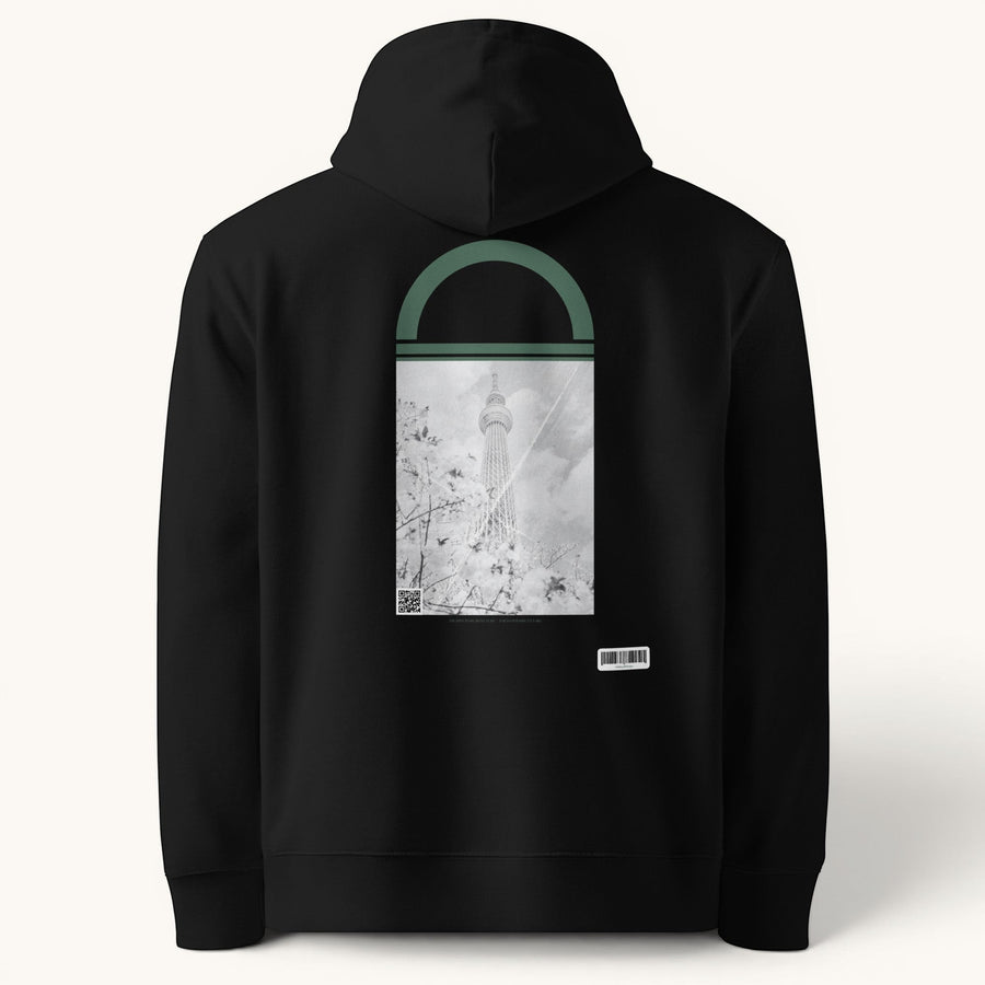 ETHIKKALL sweat à capuche unisexe noir en coton organique avec un imprimé Tokyo Skytree à travers des fleurs de cerisier.