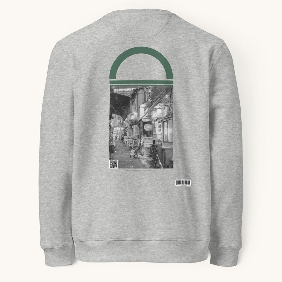ETHIKKALL sweat-shirt gris en coton biologique avec un imprimé de rue tokyoïte et un détail en demi-lune vert.