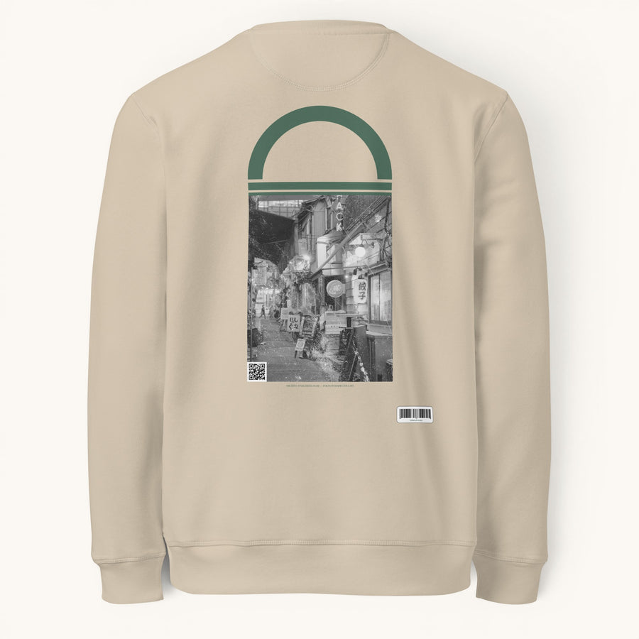 ETHIKKALL sweat-shirt unisexe beige en coton biologique avec un imprimé de rue tokyoïte en noir et blanc et un détail en demi-lune vert.