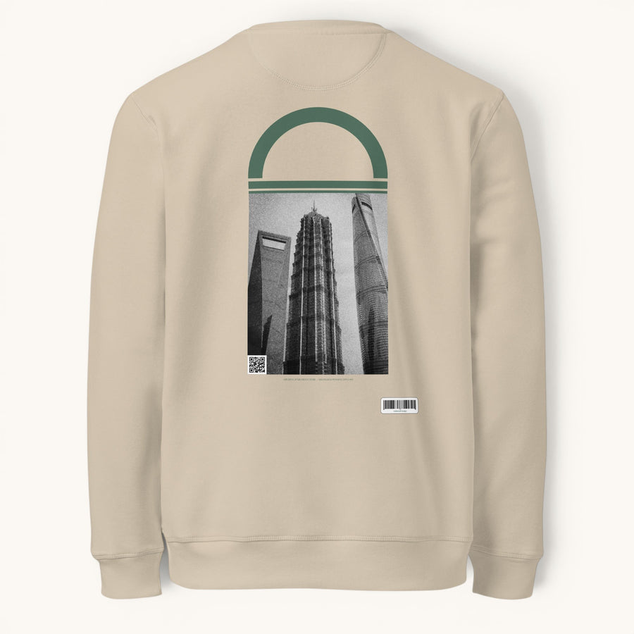 ETHIKKALL sweatshirt beige en coton biologique avec un imprimé de gratte-ciel de Shanghai et un détail en demi-lune vert.