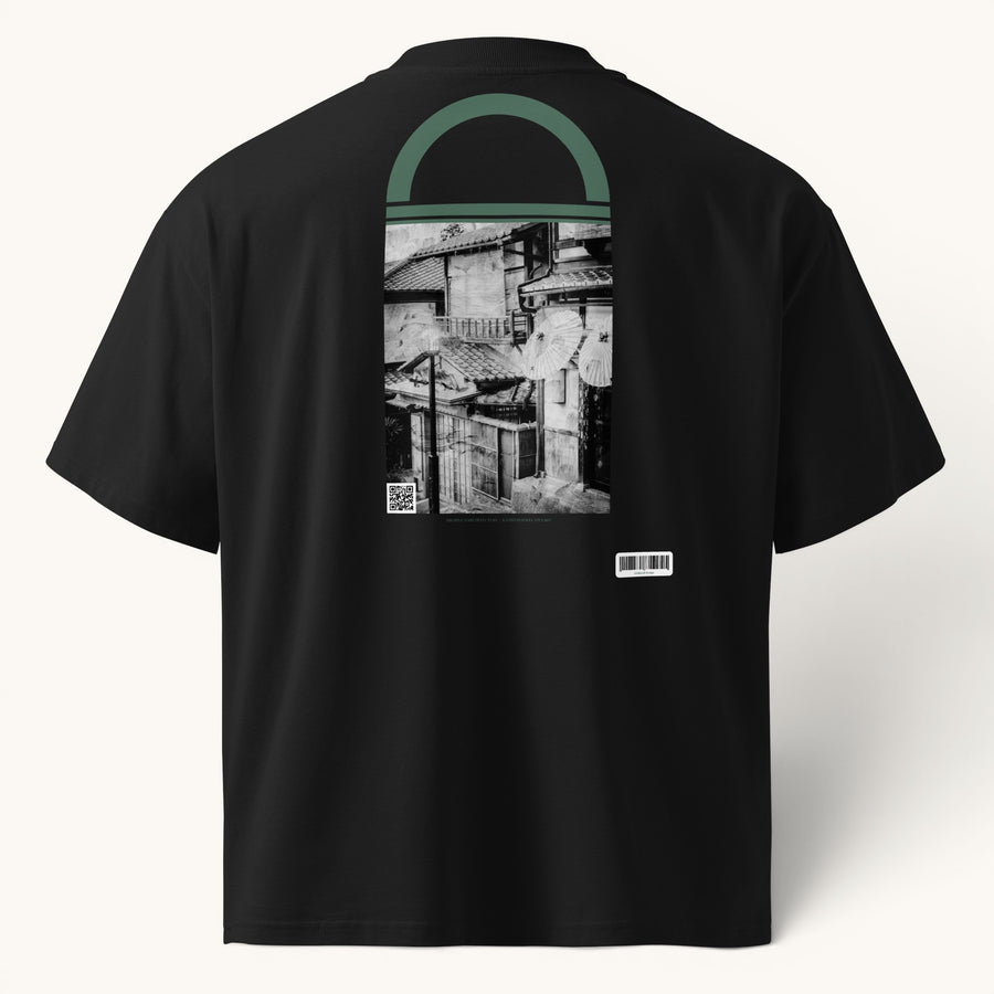 ETHIKKALL T-shirt noir ample en coton biologique avec col montant et illustration graphique d'une ruelle japonaise.